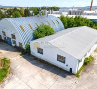 Skladový areál s pozemkom 10 000 m2 v priemyselnej zóne - Senica ponúka sklady a haly s oblúkovými plechovými strechami a priemyselnou architektúrou.