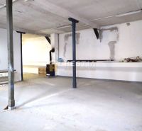 Hala na prenájom 400 m2 – priemyselná zóna - Prázdne výrobné priestory s odkrytými trámami a stenami.