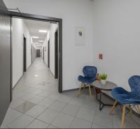 Kancelárie na PRENÁJOM | Vajnorská | TOP lokalita - Kancelárie s chodbou, modrými stoličkami a stolom, podlaha s dlažbou.