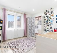MODERNÁ NOVOSTAVBA | TOPOĽČANY | MRAVENISKO - Miestnosť v rodinnom dome so CD na stene, koberec, police s nápojmi a dekoratívne vankúše.
