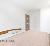 MODERNÁ NOVOSTAVBA | TOPOĽČANY | MRAVENISKO - Spálňa v rodinnom dome s posteľou, bielymi stenami a posuvnými skriňami.
