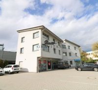 Samostatná kancelária 19,16 m2 - Lamačská cesta - Budova na ulici Lamačská cesta so zaparkovanými autami, kancelárie na prízemí, oblačné nebo.