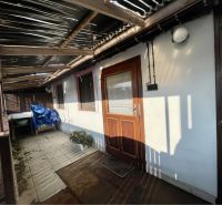 REZERVOVANÝ-VRAKÚŇ – STARÝ RODINNÝ DOM NA PREDAJ S VEĽKÝM POZEMKOM - 2 - Krytá terasa v obci Vrakúň, slúžiaca na bývanie, s drevenými doplnkami.