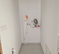 NOVOSTAVBA! 3- izbový byt so záhradkou - Úzky priestor v 3-izbovom byte s bielymi stenami a keramikou pod nohami.