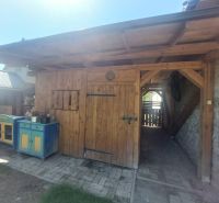 NA PREDAJ Čarovný vidiecky dom s kachľovou pecou NEMECKÁ - Drevený prístrešok pri rodinnom dome v Nemeckej, vybavený farebnými skrinkami.