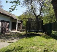 NA PREDAJ – chalupa alebo rodinný dom na pokojné bývanie  - Rodinný dom v Krajnom s garážou, záhradou, stromami a trampolínou na tráve.