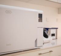 Kompletne zariadená zubná ambulancia, Záhorská Bystrica - Sterilizátor W&H Lara XL na bielej pracovnej doske v obchodnom priestore.
