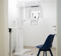 Kompletne zariadená zubná ambulancia, Záhorská Bystrica - Izba s röntgenovým prístrojom a modrou stoličkou v obchodných priestoroch.
