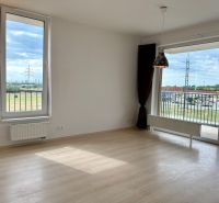 Na predaj novostavba 3 izbový byt, Bratislava, Nový Ružinov, Bajkalská - Obývacia izba v 3-izbovom byte s výhľadom na terasu a podlahou s dreveným dekorom.