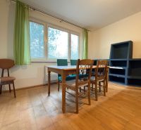 Na predaj: CENTRUM: 3 izb.byt + PIVNICA - Izba 3-izbového bytu s podlahou s dreveným dekorom, stolom a stoličkami.