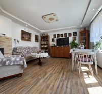 Na predaj: CENTRUM 2 izb.byt + 3x PIVNICA - Obývačka v 2-izbovom byte s dekoratívnym nábytkom a podlahou s dreveným dekorom.