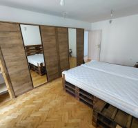 2 izbový byt v CENTRE Martina s veľkou loggiou - Spálňa v 2-izbovom byte s podlahou s dreveným dekorom a veľkou skriňou.