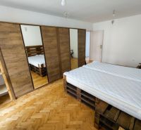 2 izbový byt v CENTRE Martina s veľkou loggiou - Spálňa v 2-izbovom byte s podlahou s dreveným dekorom a priestrannou skriňou.