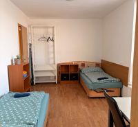 4-izbový byt, Bratislava/Nové Mesto, ulica Nová Rožňavská - Izba v 4-izbovom byte s dvoma posteľami a podlahou s dreveným dekorom.