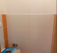 4-izbový byt, Bratislava/Nové Mesto, ulica Nová Rožňavská - Toaleta so vzorovaným sedátkom a oranžovými dlaždicami v 4-izbovom byte.