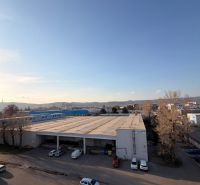 4-izbový byt, Bratislava/Nové Mesto, ulica Nová Rožňavská - Areál s parkoviskom a halou v Bratislave na Novej Rožňavskej, pozadie s panorámou.