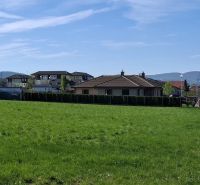 Stavebný pozemok 1212m² v obci Šelpice - Pozemok na bývanie na Slnečnej v Šelpiciach s výhľadom na domy a zeleň.