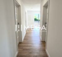 NOVINKA, na predaj tri prémiové 4 izbové byty v obci JASENOV (HE) - Chodba v 4-izbovom byte, podlaha s dreveným dekorom, svetlé steny, vstup na balkón.