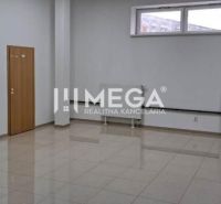 NA PRENÁJOM - kancelária v OC triada v meste Humenné - Kancelárie s bielymi stenami a oknom, podlaha s dreveným dekorom, stôl v rohu.