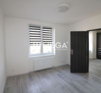 NA PREDAJ - 2 iz. byt s balkónom blízko centra mesta Humenné - Izba s podlahou s dreveným dekorom v 2-izbovom byte, biele steny, okno, dvere.