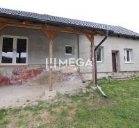 Na predaj - Dom s veľkým pozemkom v Pakostove - Rodinný dom v Pakostove s nezateplenou fasádou a trámovou verandou na ulici Pakostov.