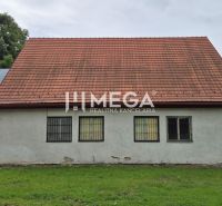 Predaj budovy v obci Zboj - Obchodné priestory v Zboji so šikmou strechou a oknami so zabudovanými mrežami.