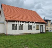 Predaj budovy v obci Zboj - Budova v Zboji s červenou strechou a trávnatým okolím. Obchodné priestory dostupné.