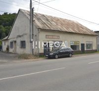 Prenájom časti komerčnej budovy na podnikanie – Stakčín - Budova na ulici Mieru v Stakčíne, využívaná ako obchodné priestory, vedľa zaparkované auto.