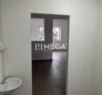 Prenájom komerčných priestorov – Snina (budova ECO umyvárky) - Interiér obchodných priestorov s umývadlom a dverami, podlaha s dreveným dekorom.