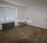 Na prenájom: Priestranný 2-izbový byt s balkónom v Humennom - Izba s podlahou s dreveným dekorom a radiátorom v 2-izbovom byte.