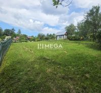 Záhrada na predaj – 365 m², Pichoňka, Snina - Pohľad na zelené záhrady v Snine s viditeľnými chatkami a modrou oblohou.