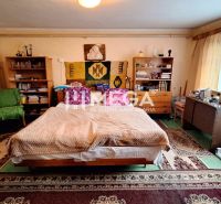 EXKLUZÍVNE NA PREDAJ:  3.podlažný dom v meste Snina - Izba v rodinnom dome s posteľou, kobercami, policami a písacím stolom.