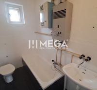 EXKLUZÍVNE NA PREDAJ rodinný dom v obci Jasenov - Kúpeľňa v rodinnom dome s vaňou, umývadlom a oknom, využíva podlahu s dreveným dekorom.