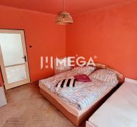 EXKLUZÍVNE NA PREDAJ 2 izbový byt na Gorkého ulici v ML - Spálňa v 2-izbovom byte s oranžovými stenami a podlahou s dreveným dekorom.