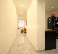 NA PRENÁJOM: Kancelárske priestory + 3-izbový apartmán – Košice - Interiér budovy s dláždenou chodbou, kuchyňou a spotrebičmi po stranách.