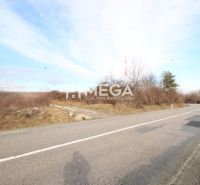 NA PREDAJ: Pozemok 3 000 m² LORINČÍK INVESTIČNÝ POTENCIÁL - Cesta vedie cez poľnohospodárske a lesné pozemky v Košiciach II, lemovaná stromami a kríkmi.