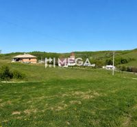 NA PREDAJ: Priestranný pozemok 2126 m² obec Víťazovce – ideálny na výs - Trávnaté pozemky na bývanie v dedine Víťazovce obklopené zelenými kopcami a budovami.