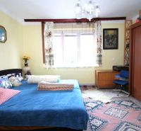 NA PREDAJ RODINNÝ DOM – MYSLINA ( len 6 km od Humenného) - Spálňa v rodinnom dome s modrou posteľou, dreveným nábytkom a farebným kobercom.