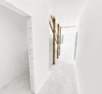 Na predaj 5-izbový rodinný dom  - Biela chodba v rodinnom dome s dočasným zábradlím na schodisku.