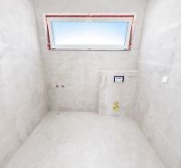 Na predaj 5-izbový rodinný dom  - Kúpeľňa v rodinnom dome s jednoduchým dizajnom, šedé steny a úzky oblok.