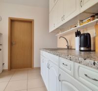 PRIESTRANNÝ BYT NA KARPATSKEJ ULICI, 80M2, SÁSOVÁ - Biela kuchyňa s pracovnou doskou, úložným priestorom a keramickou podlahou v 3-izbovom byte.