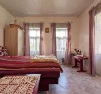 TRADIČNÝ DOM V SRDCI TAJOVA, 893 M2, TAJOV - Spálňa v rodinnom dome s posteľou, komodou a veľkými oknami s fialovými závesmi.