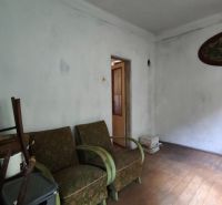 Znížená cena!!! Vidiecky dom v obci Olováry v okrese Veľký Krtíš. - Izba v rodinnom dome s nábytkom a podlahou s dreveným dekorom.