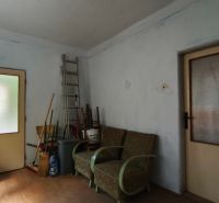 Znížená cena!!! Vidiecky dom v obci Olováry v okrese Veľký Krtíš. - Izba v rodinnom dome s kreslami, rebríkom a metlami na podlahe s dreveným dekorom.