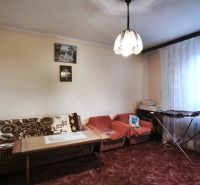 Znížená cena!!! RD (pozemok 9756 m2)  v osade Prieloh, okr. V. Krtíš. - Obývačka v rodinnom dome s pohovkami, stolom a záclonami na okne.