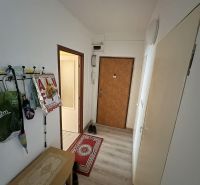 Váš nový štart alebo bezpečná investícia v srdci Šiah - Chodba v 2-izbovom byte s podlahou s dreveným dekorom, vešiakom a botníkom.