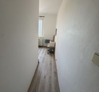 Váš nový štart alebo bezpečná investícia v srdci Šiah - Úzka chodba v 2-izbovom byte s podlahou s dreveným dekorom.