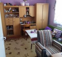 Váš nový rodinný prístav v obci Iža: Priestor, kľud a čerstvá úroda z  - Obývacia izba v Rodinnom dome s fialovými stenami a dreveným nábytkom.