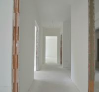 3-izbový byt s balkónom v Rezidencii Madone - Svetlá chodba v 3-izbovom byte s neomietnutými stenami a betónovou podlahou.