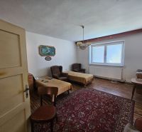 Na predaj rodinný dom s veľkou záhradou v centre V.Šariša - Izba v rodinnom dome so starším nábytkom, podlaha s dreveným dekorom, červený koberec.